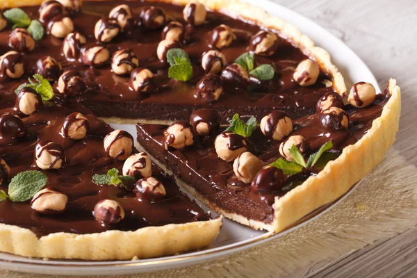 Cut the chocolate tart with hazelnut close-up, horizontal — Stock Photo, Image