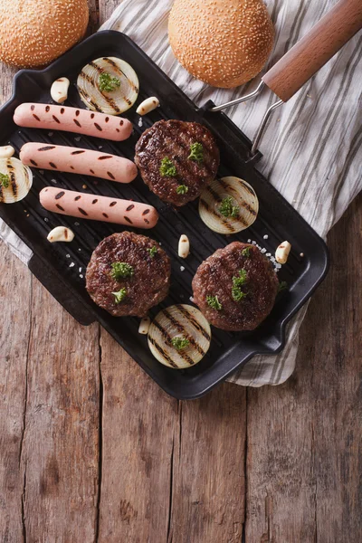 Gegrillte Burger und Hot Dogs auf der Grillpfanne. vertikale Ansicht von oben — Stockfoto