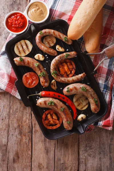 Sausages with vegetables in a pan grill.  Vertical top view — Stock Photo, Image