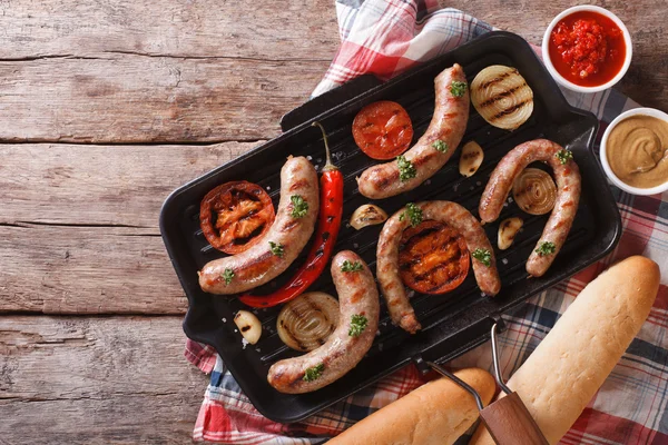 Grill kolbászt egy serpenyőben zöldségekkel. vízszintes felülnézet — Stock Fotó