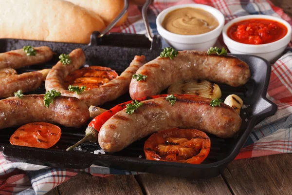 Gegrilde worstjes op een grill pan, broodjes met saus. Horizontale — Stockfoto