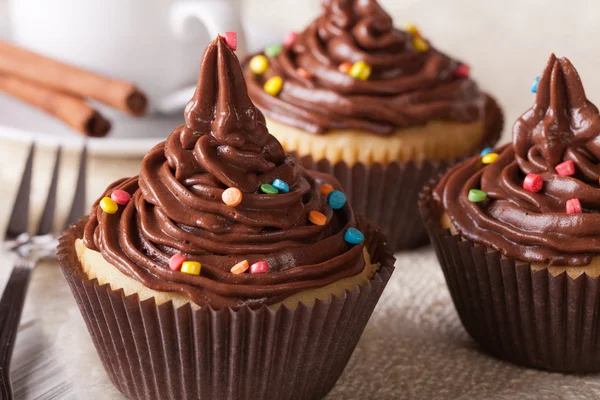 Cupcakes with chocolate cream close-up and coffee, horizontal — Stock Photo, Image