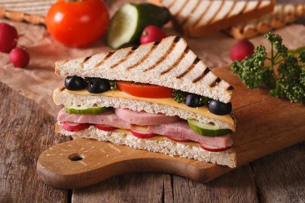 Сэндвич с ветчиной, овощи на доске горизонтально — стоковое фото