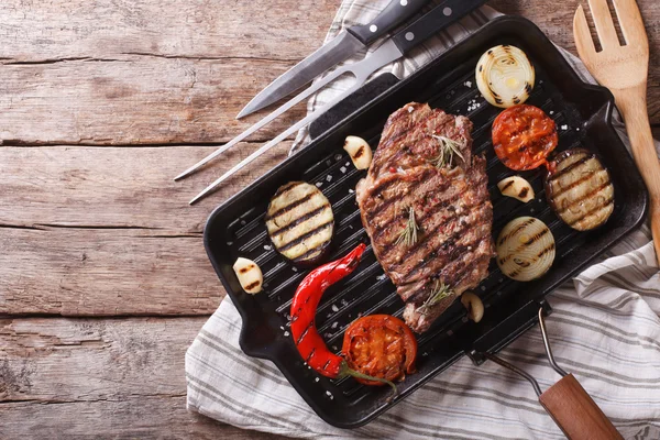 Gegrilde biefstuk met groenten in de pan. horizontale bovenaanzicht — Stockfoto