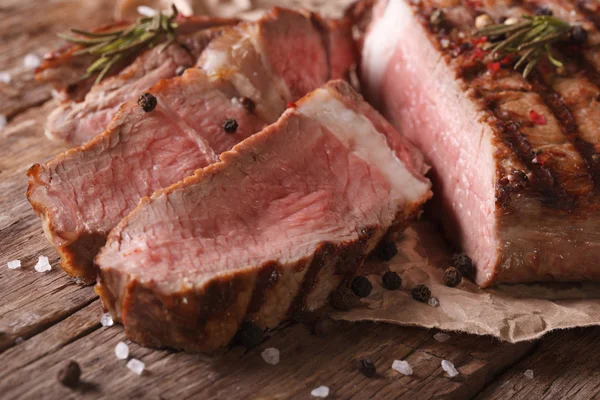 Bife grelhado fatiado em uma mesa velha. close-up horizontal — Fotografia de Stock