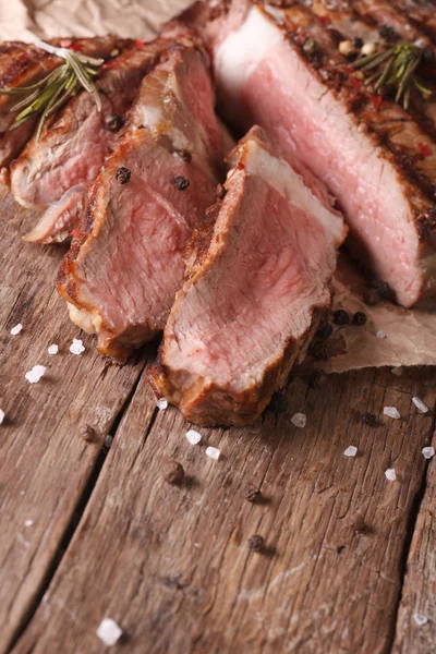 Sliced beef steak medium on an old table. Vertical close-up — Stock Photo, Image