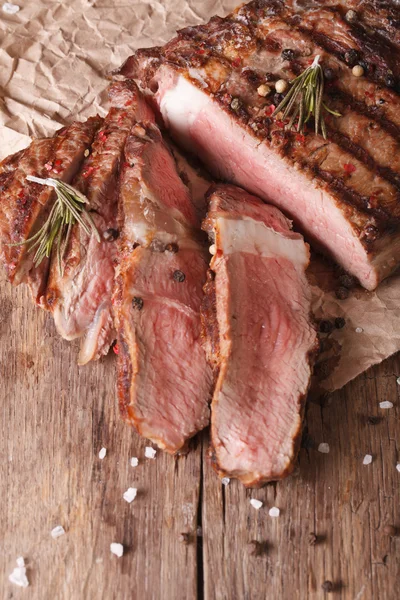 Plátky biftek na grilu na dřevěné vertikální pohled nad — Stock fotografie