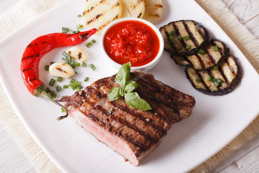 beef steak, grilled vegetables and sauce horizontal top view