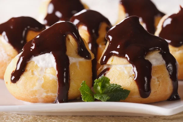 Profiteroles frescos con macro glaseado de chocolate. horizontal —  Fotos de Stock