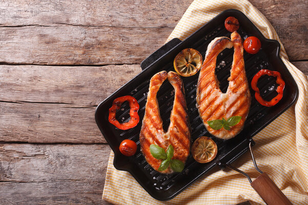 Salmon steak with vegetables on a grill pan. horizontal top view