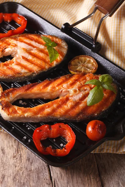 Two salmon steak and vegetables on the grill, vertical — Stock Photo, Image