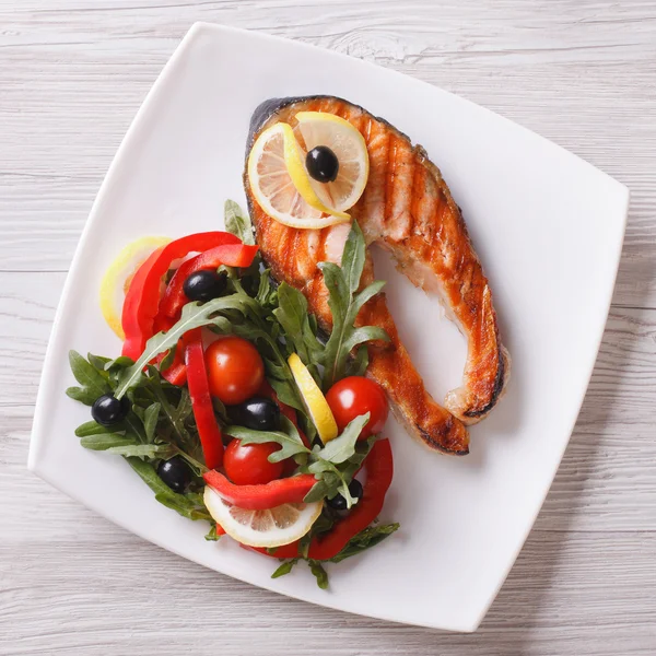 Gegrilltes rotes Fischsteak und Gemüsesalat von oben aus nächster Nähe — Stockfoto