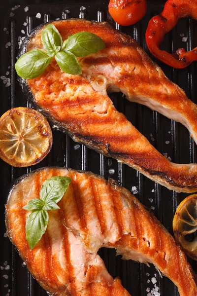 两个烤的牛排红色鱼三文鱼和蔬菜在烤架上 — 图库照片