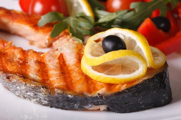 Bife de salmão grelhado com limão em um prato macro — Fotografia de Stock