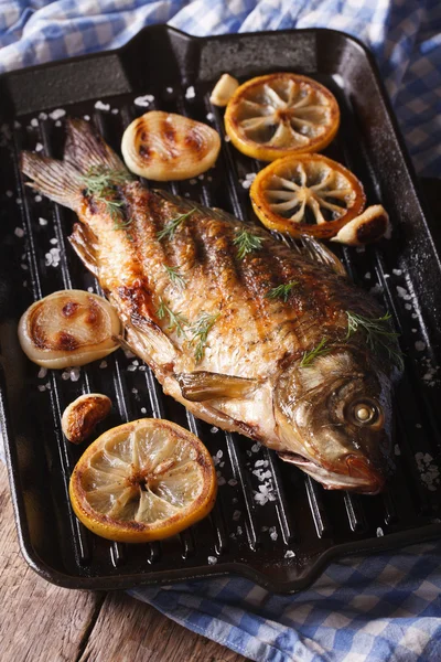 Carpa di pesce con limone e cipolla sulla griglia, verticale — Foto Stock