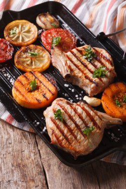 Izgara domuz, kabak ve limon bir ızgara tava üzerinde. Dikey