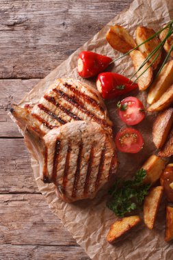 Kağıt üstten görünüm dikey olarak patates ile domuz eti biftek ızgara