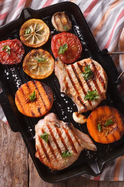 Gegrilde varkensvlees en pompoen op een grill pan. Verticale bovenaanzicht sluiten — Stockfoto