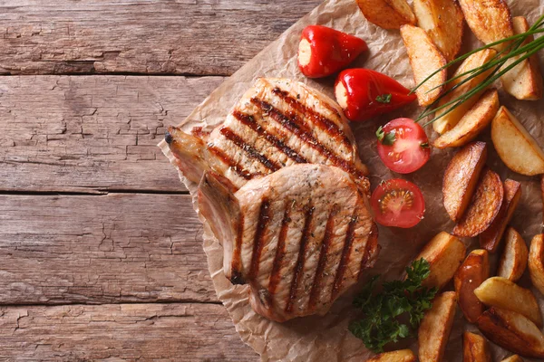 紙上面水平にジャガイモと豚肉ステーキ — ストック写真