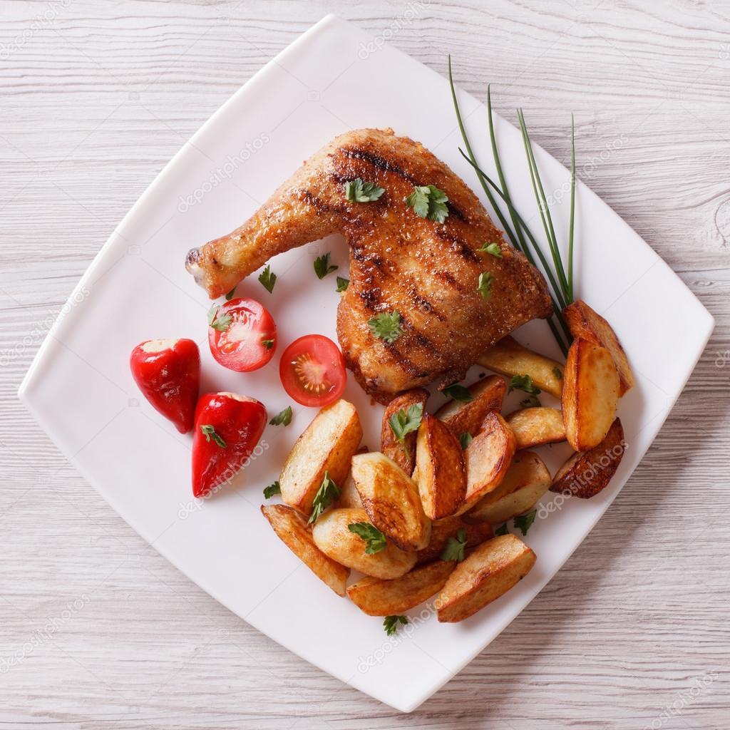 Chicken thighs and chips on a plate. top view 