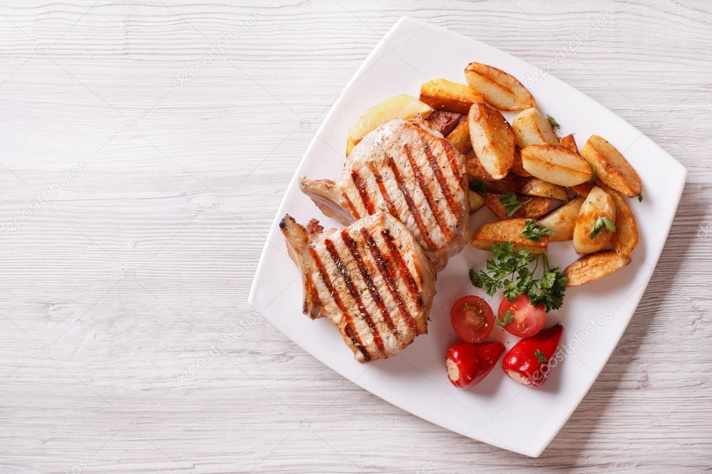 pork steak and fried potatoes top view horizontal