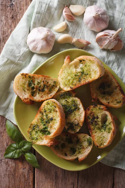 Toasty s bazalkou a česnekem close-up, pohled shora vertikální — Stock fotografie