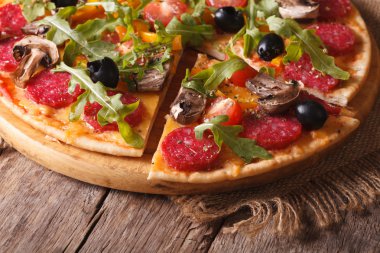 Pizza rucola, salam ve zeytin yakın çekim yatay