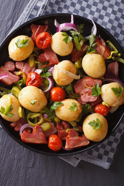 Potatoes with fried bacon and herbs on a plate, top view — Stock Photo, Image