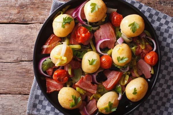 Żywność w rustykalne: młode ziemniaki z boczkiem na talerzu. Poziome najwyższym vi — Zdjęcie stockowe