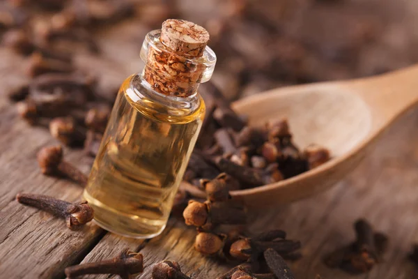 Clove oil in a bottle close-up on the table, rustic — Stock Photo, Image
