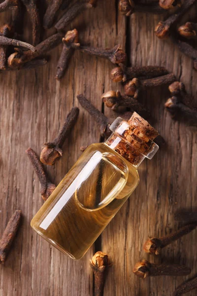 Oil of cloves in the bottle close-up vertical top view — Stock Photo, Image