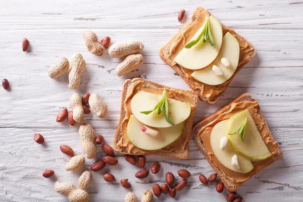 sandwiches with peanut butter and an apple horizontal top view