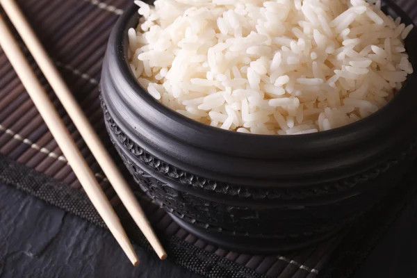 Cibo asiatico: riso bollito in una ciotola nera macro orizzontale — Foto Stock