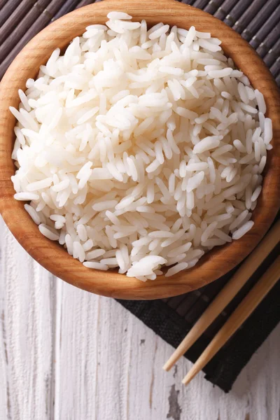 Азиатская еда: рис в деревянной миске крупным планом. вертикальный вид сверху — стоковое фото