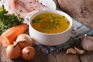 Tavuk suyu ve malzemelerin üzerine tablo yakın çekim. Yatay