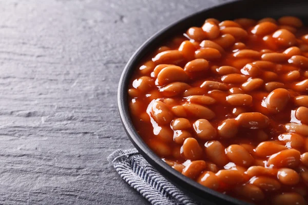 Feijão em molho de tomate em uma tigela preta — Fotografia de Stock