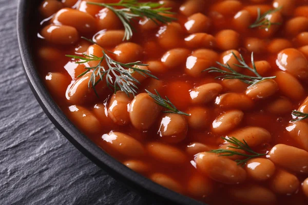 Vita bönor i tomat svart skål närbild vågrätt — Stockfoto