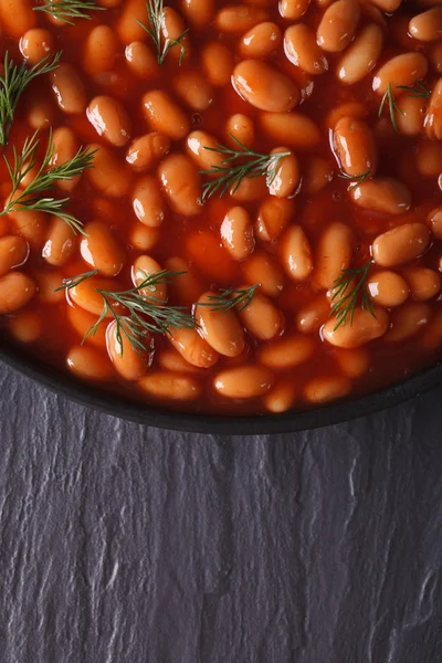 Frijoles blancos en tomate en un bol negro vista superior vertical —  Fotos de Stock