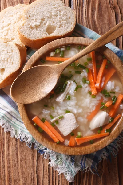 Comida rústica: sopa de arroz en un tazón de madera. vista superior vertical —  Fotos de Stock