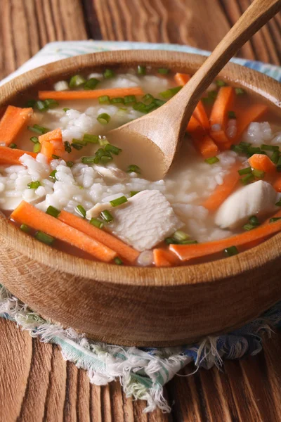 Comida caseira: Sopa de arroz de frango em uma tigela de madeira. Vertical — Fotografia de Stock