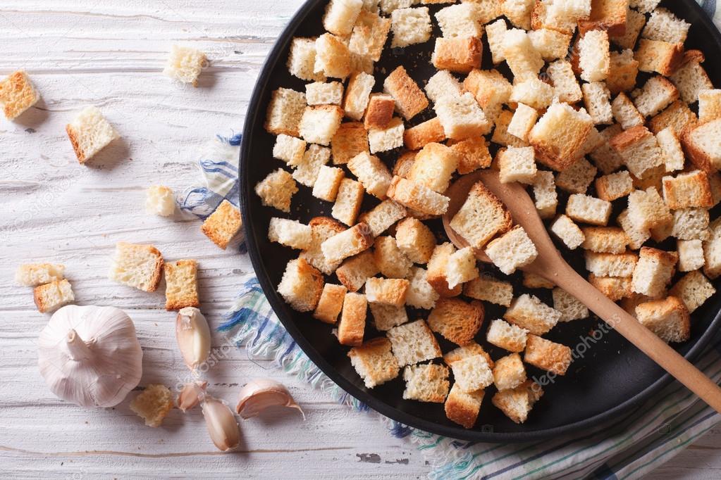 Delicious fried croutons with garlic horizontal top view