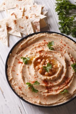 Humus kırmızı biber ve maydanoz üzerinde plaka closeup ile. dikey