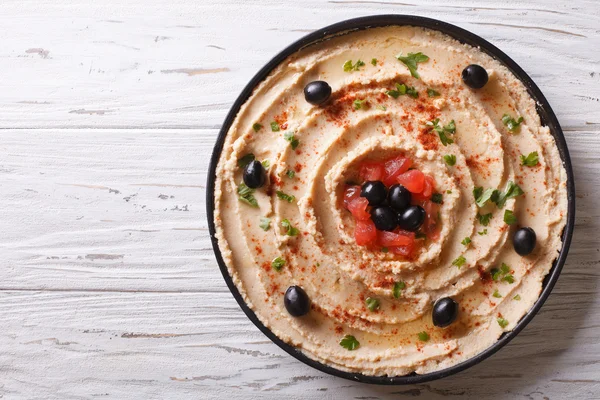 Frischer Hummus mit Oliven und Tomaten. horizontale Ansicht von oben — Stockfoto