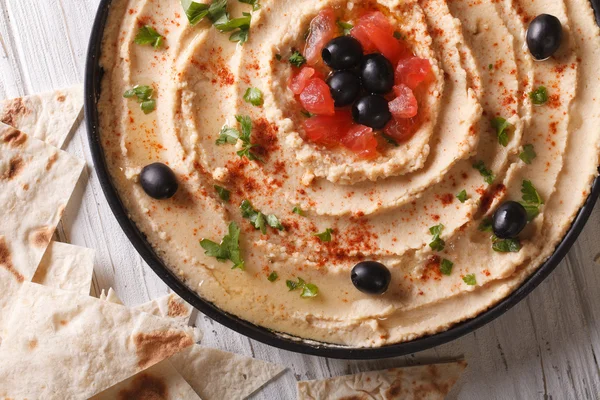 Hummus with olives and tomatoes horizontal top view — Stock Photo, Image