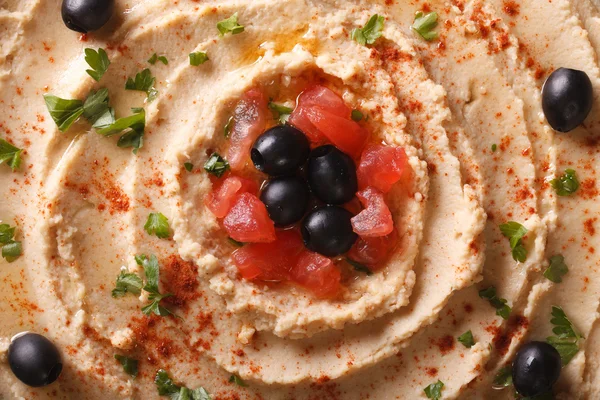 Hummus with olives and tomatoes macro. horizontal top view — Stock Photo, Image