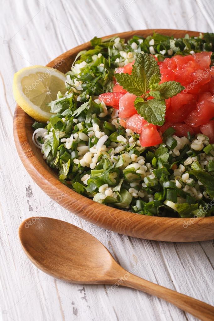 Tabbouleh salad closeup in a bowl on the table. Vertical