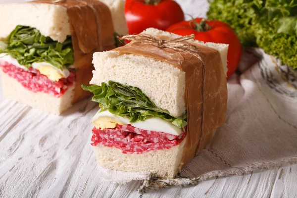 Бутерброды с салями, завернутые в бумагу крупным планом — стоковое фото