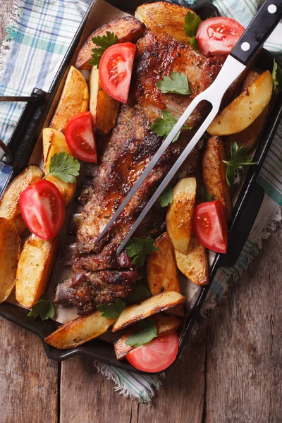 Alimente de casă: carne de porc, cartofi și roșii pe o tigaie. verticală t — Fotografie, imagine de stoc