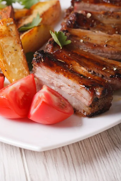 Roasted pork ribs, potatoes and tomatoes macro. vertical — Stock Photo, Image