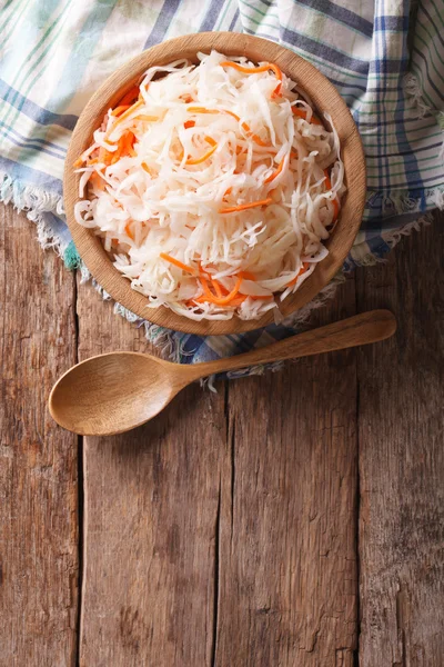 Sauerkraut and carrots in a wooden plate. vertical top view — Stock Photo, Image